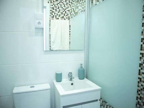 a white bathroom with a sink and a mirror at Casa 4 Peixes in Leiria