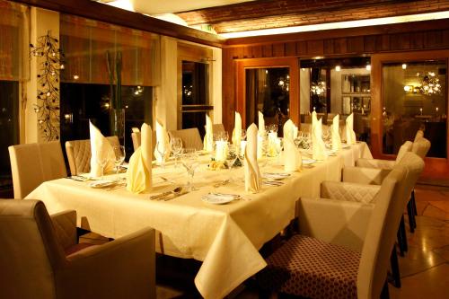 a long table with white tables and chairs in a room at Flair Hotel Nieder in Bestwig