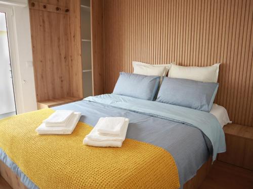 a bedroom with a bed with two towels on it at Casa 4 Peixes in Leiria