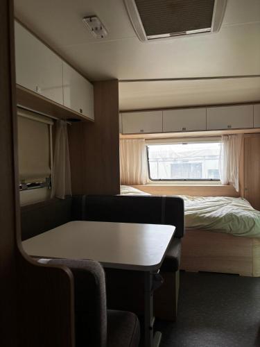 a small room with a bed and a table and chairs at קרוואן עם חיוך in Odem