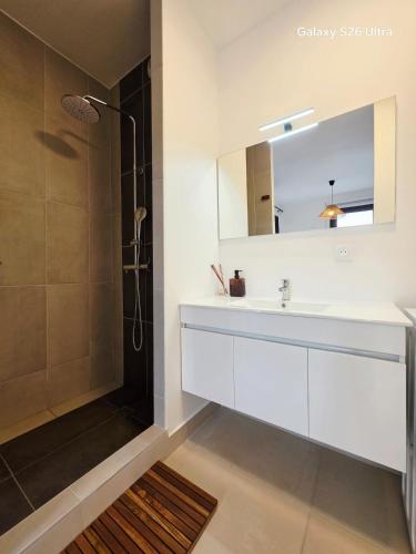 a bathroom with a white sink and a shower at Cozy Melody in Pirae