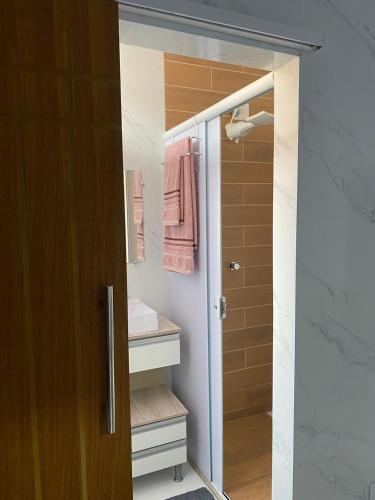 a bathroom with a walk in shower and a sink at APTO - Espaço Vix II in Vitória