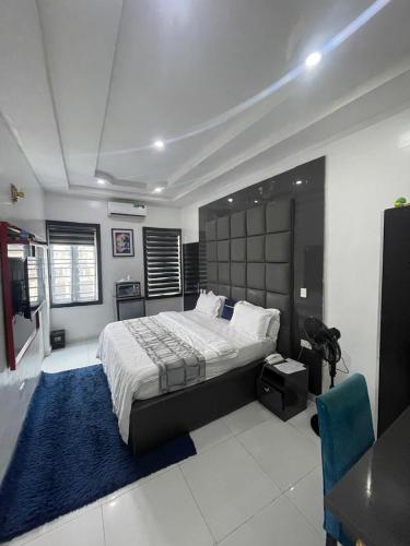 a bedroom with a large bed and a blue rug at JRC Chariot Luxury Apartment in Omole