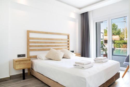 a bedroom with a bed with white sheets and a window at Sör Apart Otel in Bodrum City
