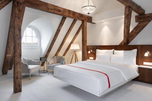 ein Schlafzimmer mit einem großen weißen Bett und einem Stuhl in der Unterkunft Ruby Mimi Hotel Zurich by IHG in Zürich