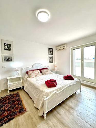 a bedroom with a white bed with red towels on it at La Mansarda - Terrazze Relax A Due in Cellamare