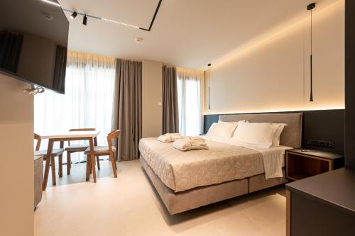 a bedroom with a bed and a table and a dining room at AVAIA boutique hotel in Nea Moudania