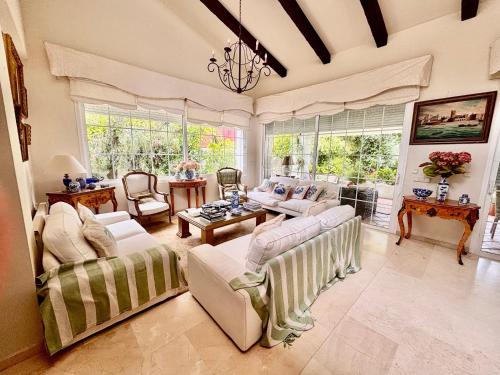a large living room with couches and a chandelier at Olmo tree in Vista Hermosa