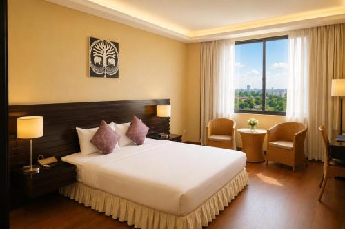 a hotel room with a bed and a large window at Savan Resorts in Savannakhet