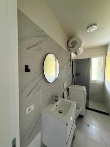 a bathroom with a sink and a toilet and a mirror at Shengjin Apartament 5 M in Shëngjin