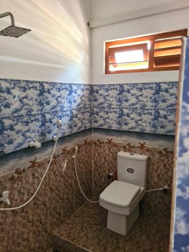 a bathroom with a toilet and a shower at Kanthans Lighthouse Cabanas in Komari