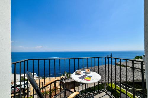 a table on a balcony with a view of the beach at Terrazza di Rosa - sea view in Praiano