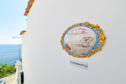 a sign on the side of a building with the ocean in the background at Terrazza di Rosa - sea view in Praiano