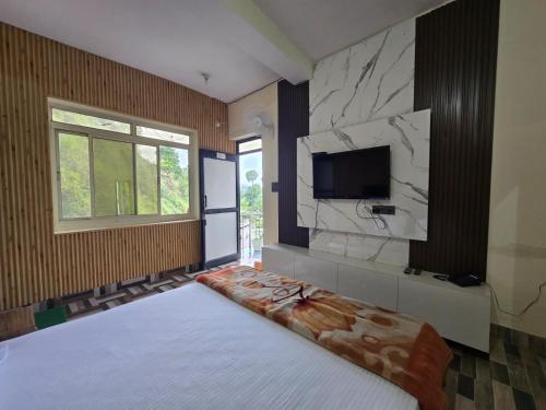 a bedroom with a bed and a tv on a wall at DWARIKA HOTEL in Dwārāhāt