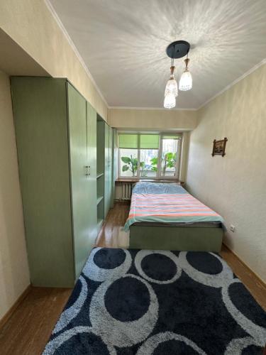 a bedroom with a bed and a large rug at Bishkek Apartment Central in Bishkek