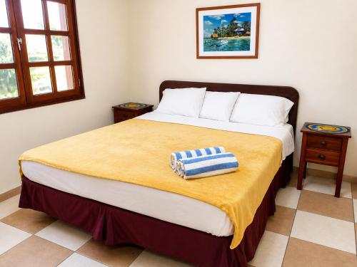 a bedroom with a large bed with a yellow blanket at POCO POCO Villa - Poolside Golf & Beachfront Resort in Dorp Sint Michiel