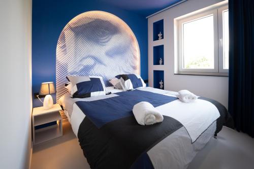 a bedroom with a large bed and a window at Capsule Santorini - balneo - Sauna - Switch 2 in Limelette
