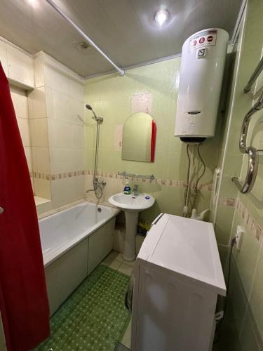 a bathroom with a tub and a sink and a bath tub at Bishkek Apartment Central in Bishkek