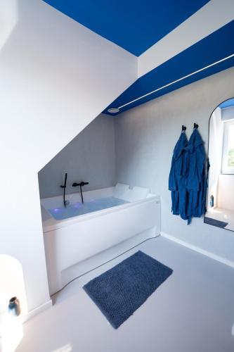 a white bathroom with a sink and a window at Capsule Santorini - balneo - Sauna - Switch 2 in Limelette