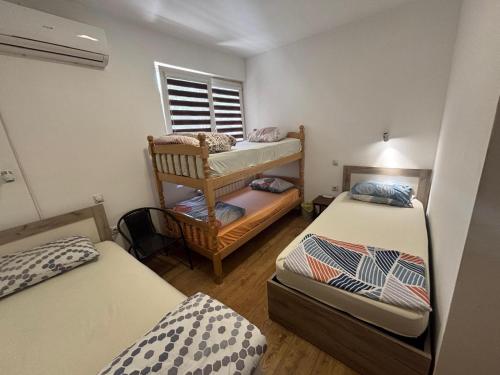 a small room with two beds and a window at Atlas Hostel in Skopje