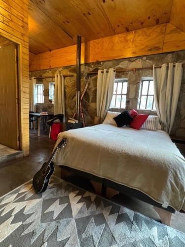 a bedroom with a large bed in a cabin at Refugio de Montaña Placaroja in San José de Maipo