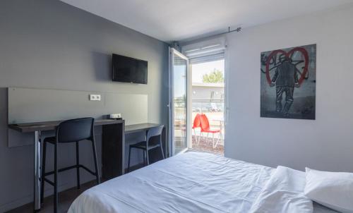 a bedroom with a bed and a desk and a table at Vacancéole - Le Terral - Montpellier Sud in Saint-Jean-de-Védas