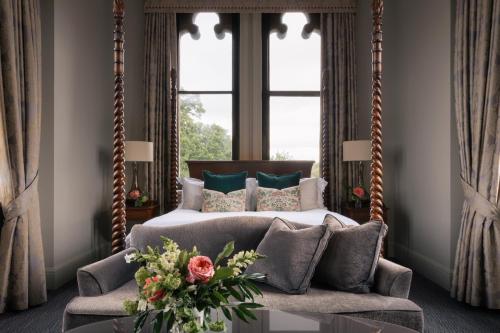 a bedroom with a bed and a large window at Nutfield Priory Hotel & Spa in Redhill