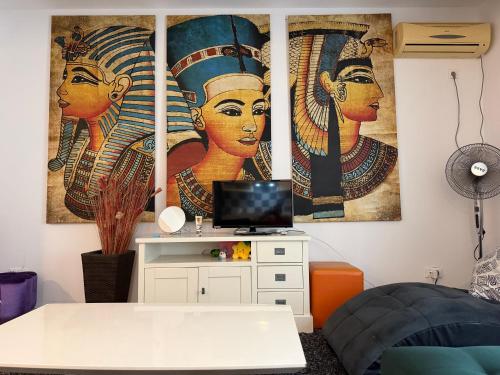 a room with two paintings of women on the wall at LUANA Apartament Mamaia Nord in Mamaia Sat/Năvodari