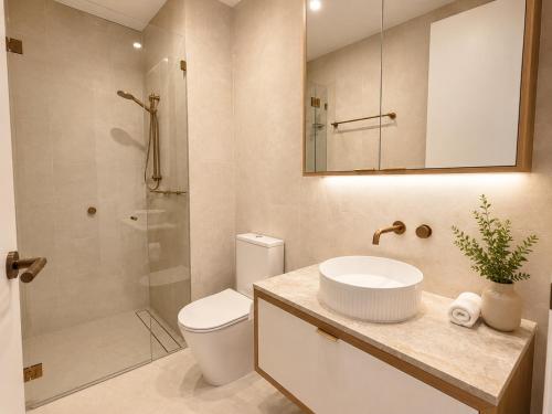 a bathroom with a toilet and a sink and a shower at Lumi Residence Robina in Gold Coast