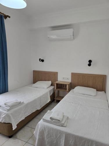 two beds sitting next to each other in a room at Golden Pension in Patara
