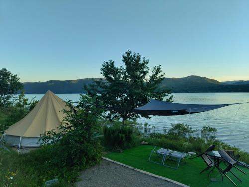 a tent and chairs next to a lake at Lakeview Glamping in Staro Myasto