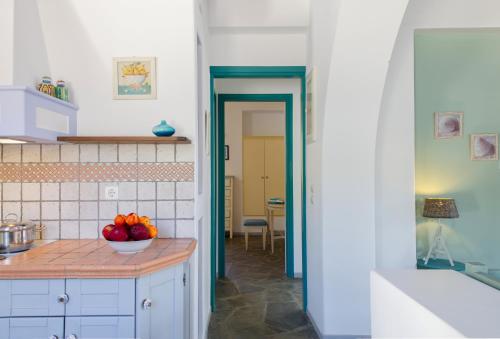 a kitchen with a bowl of fruit on a counter at Nefeli Hotel Leros in Agia Marina