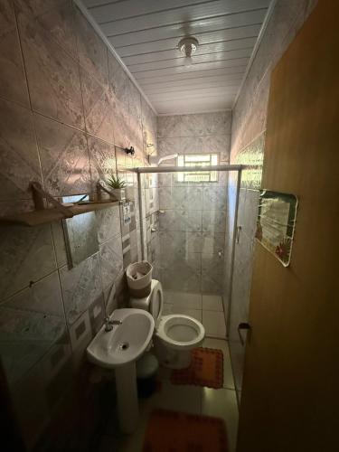 a bathroom with a shower and a toilet and a sink at Casa de Gente Feliz in Cuiabá