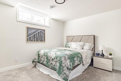 a bedroom with a bed with a green and white bedspread at Hotchlair Private Suite with Kitchen, Dining & Cozy Living Area in Calgary