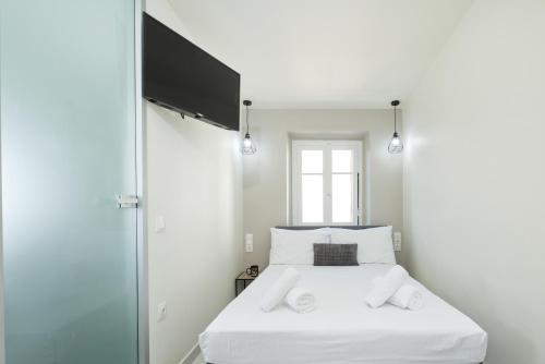 a bedroom with a white bed with two white towels at Casa Petridou 2 in Corfu