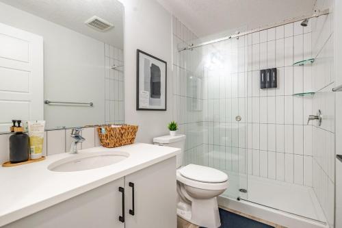 a bathroom with a toilet and a shower and a sink at Hotchlair Private Suite with Kitchen, Dining & Cozy Living Area in Calgary