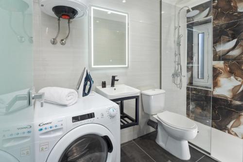 a bathroom with a washer and a toilet and a sink at Casa Petridou 2 in Corfu