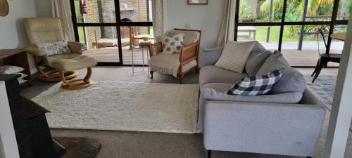 a living room with two chairs and a couch at Point Wells Village Bach in Omaha