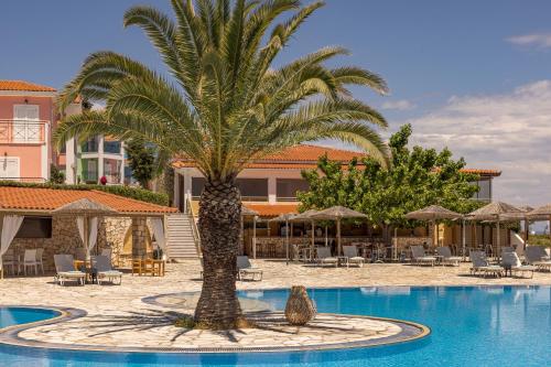 a palm tree in the middle of a swimming pool at Porto Skala Village Hotel in Skala