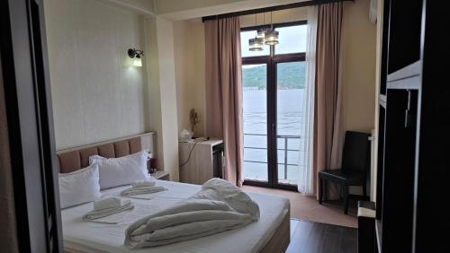 a bedroom with a bed and a large window at Pensiunea Damiro in Orşova