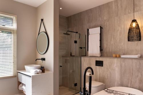 a bathroom with a sink and a toilet and a mirror at Secret Sands in Wilderness