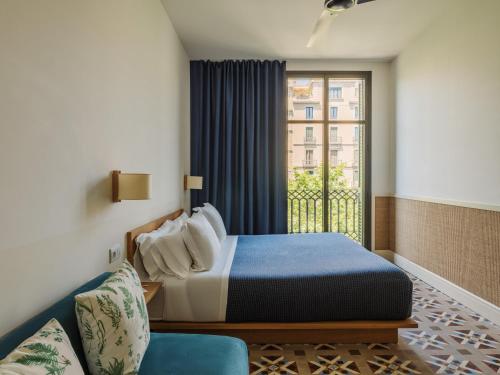 a bedroom with a bed and a window and a couch at Hotel Casa Bonay & Spa in Barcelona