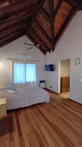 a large bedroom with a bed and a wooden floor at Casa Tala in Villa Las Rosas