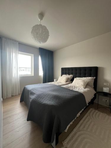 a bedroom with a large bed and a window at Mistar Home in Gardur