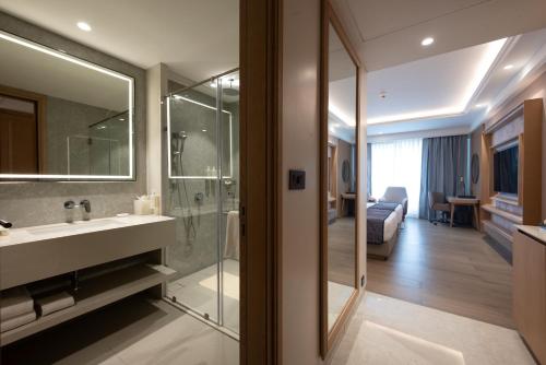 a bathroom with a sink and a mirror and a bedroom at Hotel Express Inn Heritage Aurangabad Airport in Aurangabad