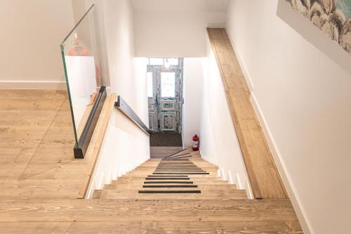 a hallway with white walls and a staircase with wooden floors at Art Studios Gialova Navarino in Gialova