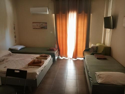a small room with two beds and a window at ELENAs in Kallithea Halkidikis