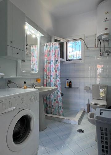 a bathroom with a washing machine and a shower at House by the sea! in Platamonas
