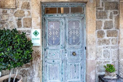 a blue door on the side of a stone building at Art Studios Gialova Navarino in Gialova