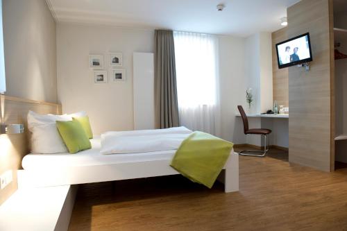 a hotel room with a white bed and a desk at Volkspark in Bamberg